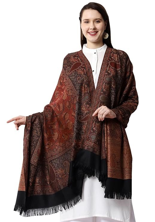 Woman wearing a brown printed woolen shawl with fringe detailing over a white outfit for winter fashion
