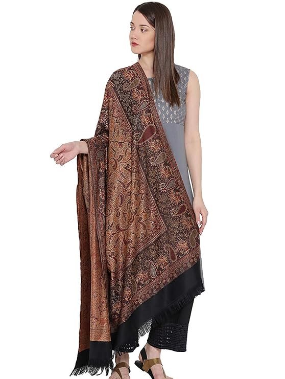 Woman wearing a brown printed woolen shawl with fringe detailing over a white outfit for winter fashion
